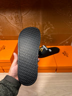 Hermes black slide sandal outsole with textured pattern and logo