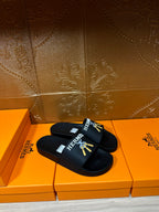 Hermes black slide sandals, gold logo design on top strap