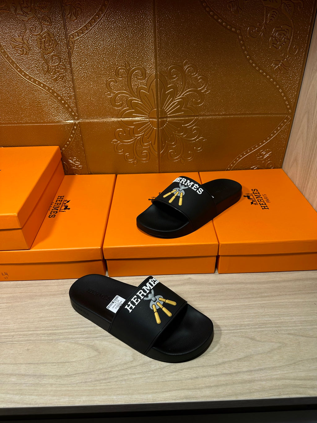 Hermes black slide sandal pair with gold logo on wide front strap