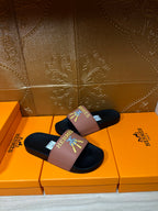 Hermes single slide sandal, mauve strap on dark footbed with Hermes logo and motif.