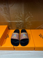 Hermes slide sandals with dark footbed and mauve strap, colorful logo detail on top.