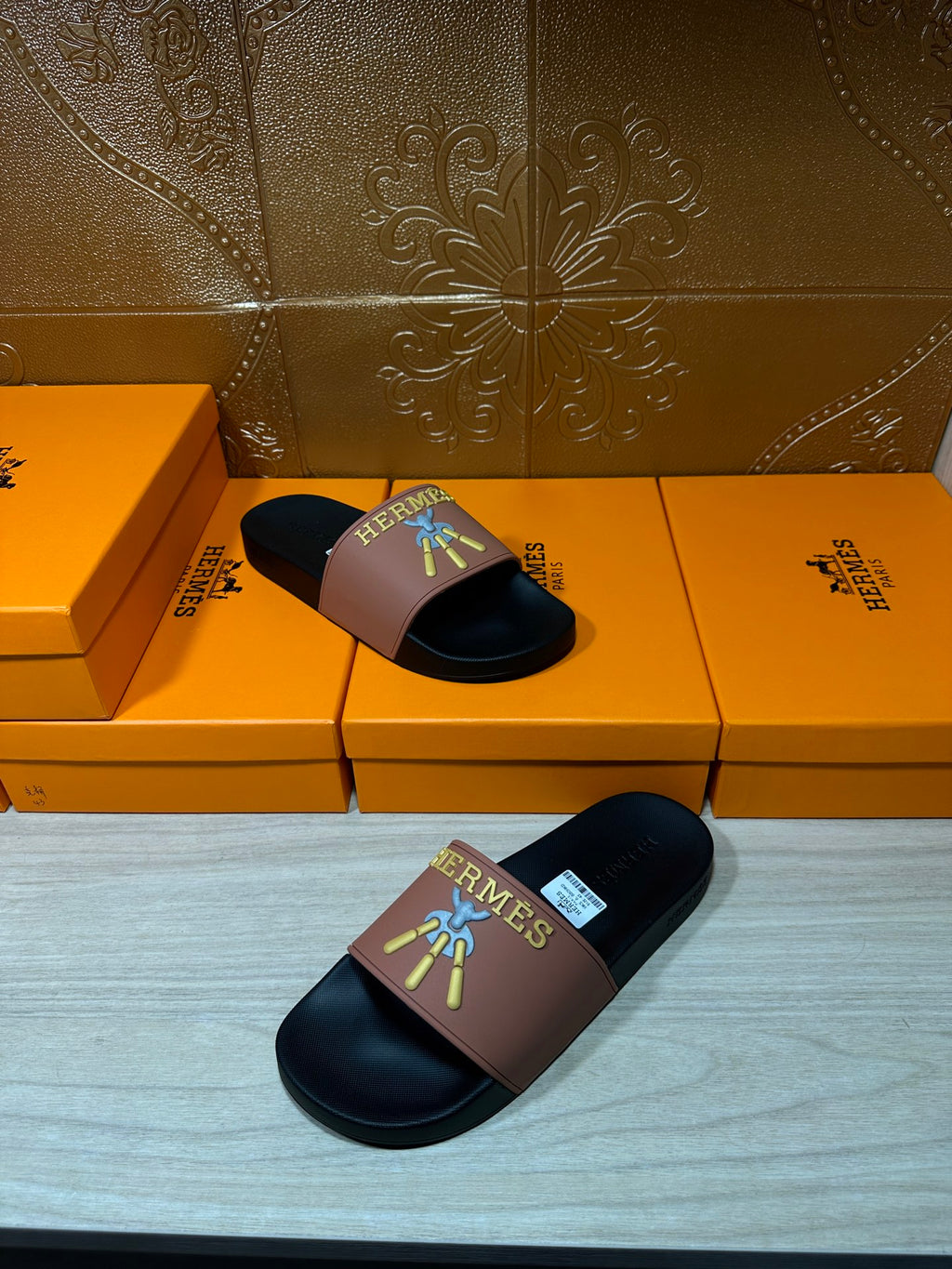 Hermes slide sandals shown with one on top, mauve strap and dark footbed with logo.