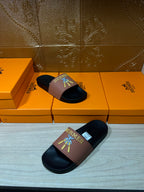 Hermes slide sandals shown with one on top, mauve strap and dark footbed with logo.