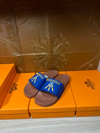 Hermès slide sandals, two matching blue straps over tan footbeds
