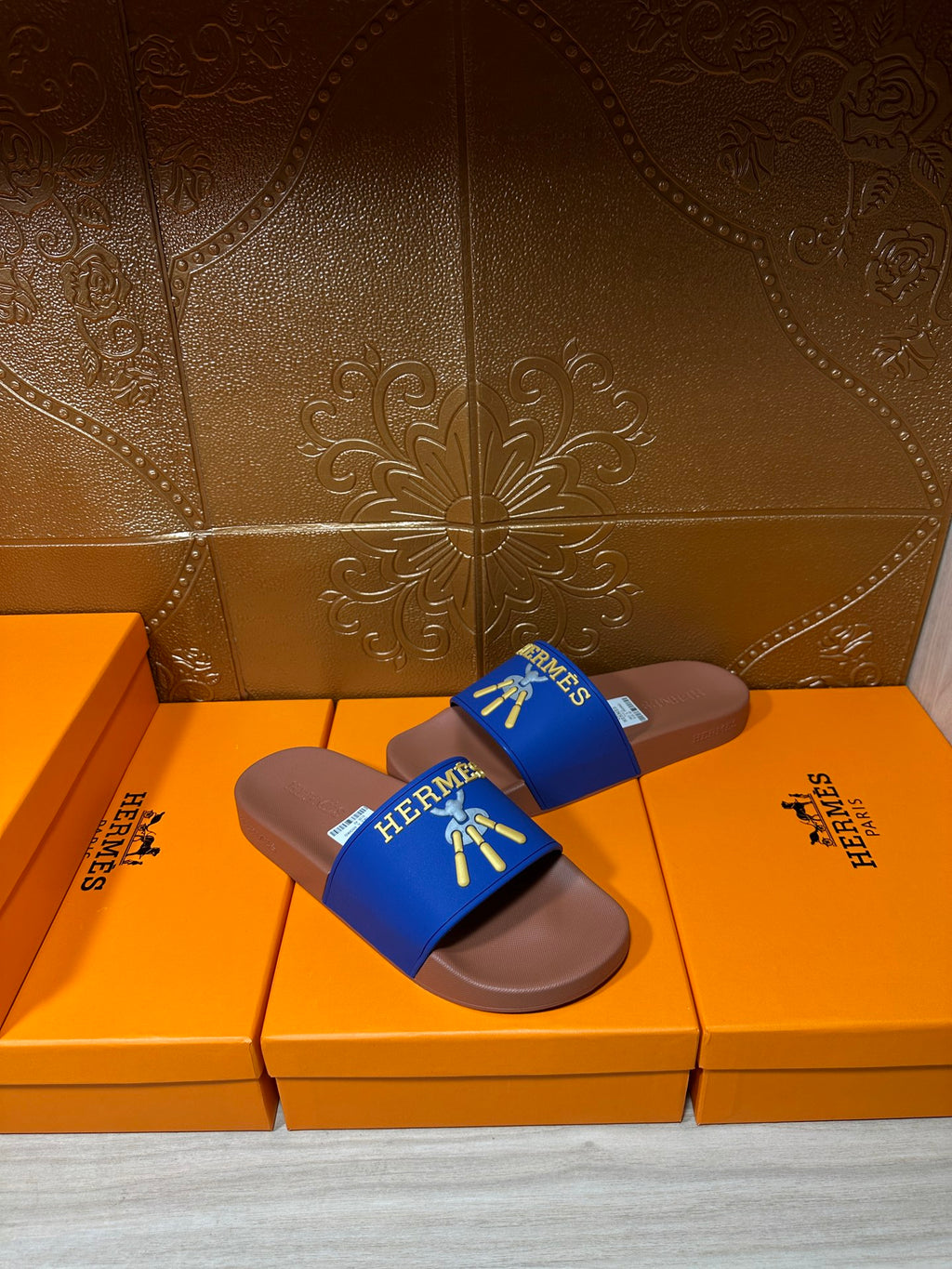 Hermès slide sandals in blue with tan footbeds, gold logo detail