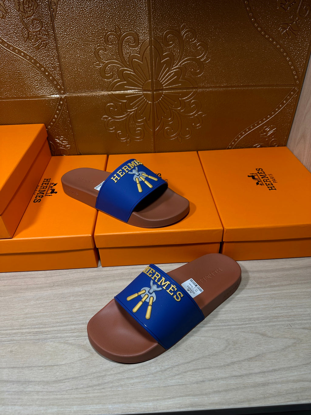 Hermès slide sandals with blue straps and tan footbeds, front view