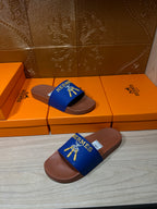 Hermès slide sandals with blue straps and tan footbeds, front view