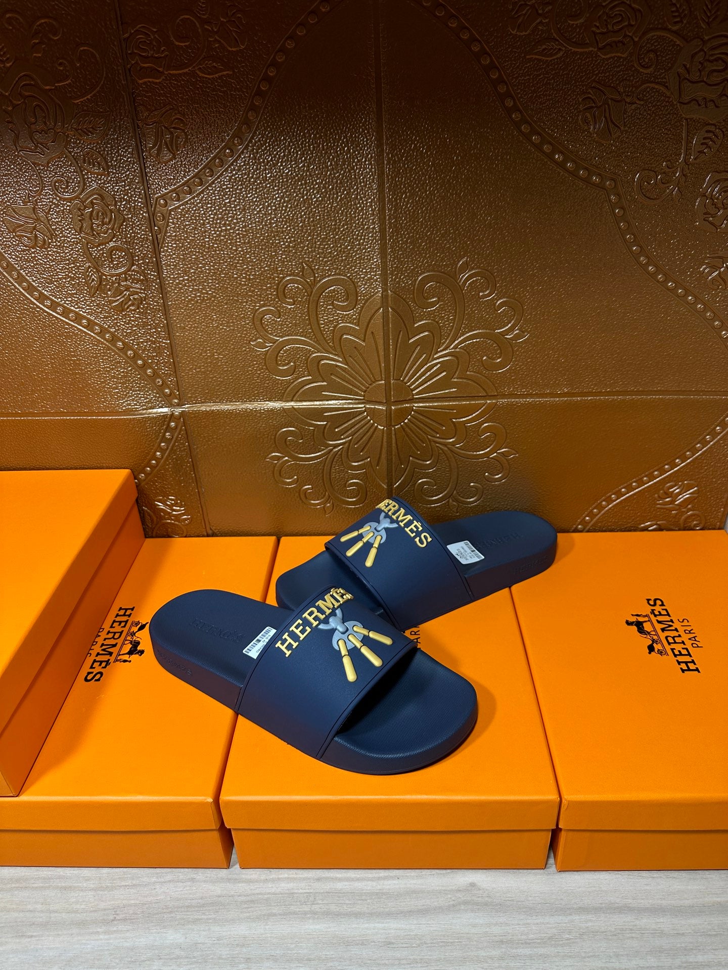 Hermes blue slide sandals side view, gold HERMES logo and charm graphic