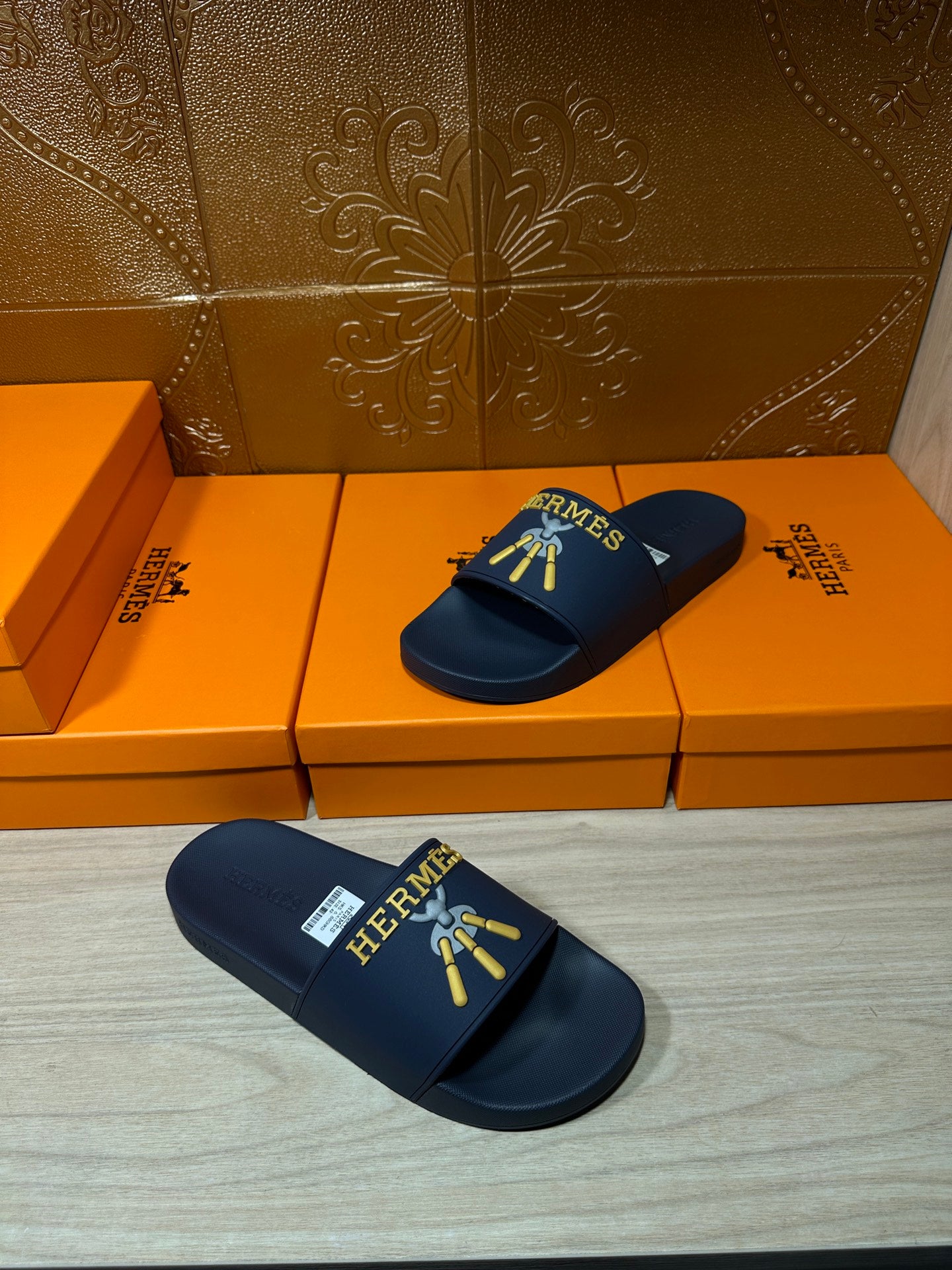 Hermes blue slide sandals pair, gold HERMES logo and charm graphic