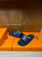 Hermes blue slide sandals, strap with gold HERMES logo and charm graphic