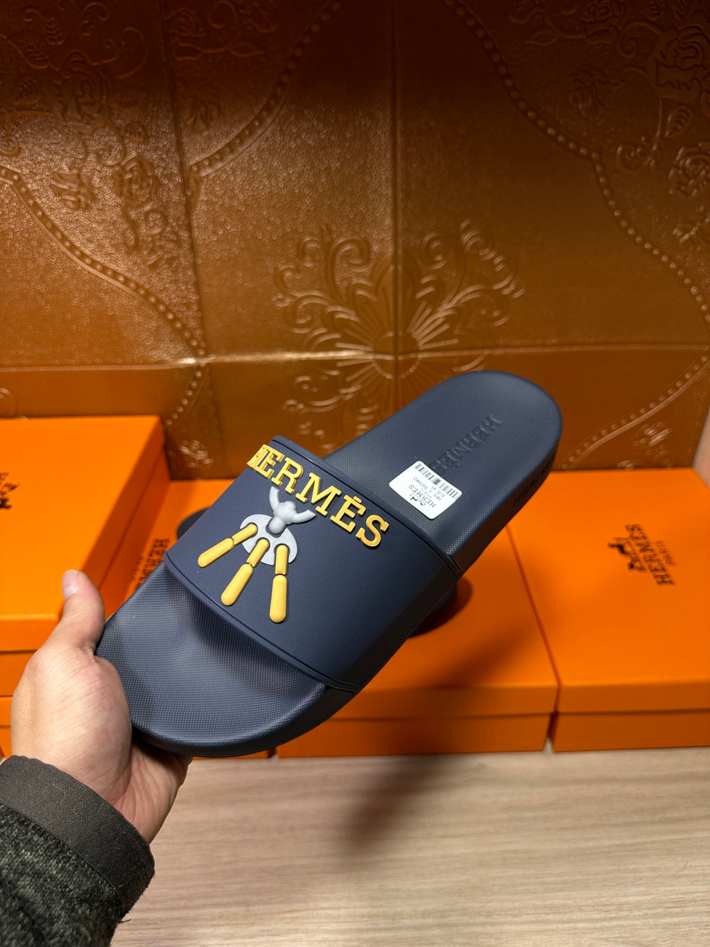 Hermes blue slide sandal on box, gold HERMES logo and charm graphic on strap