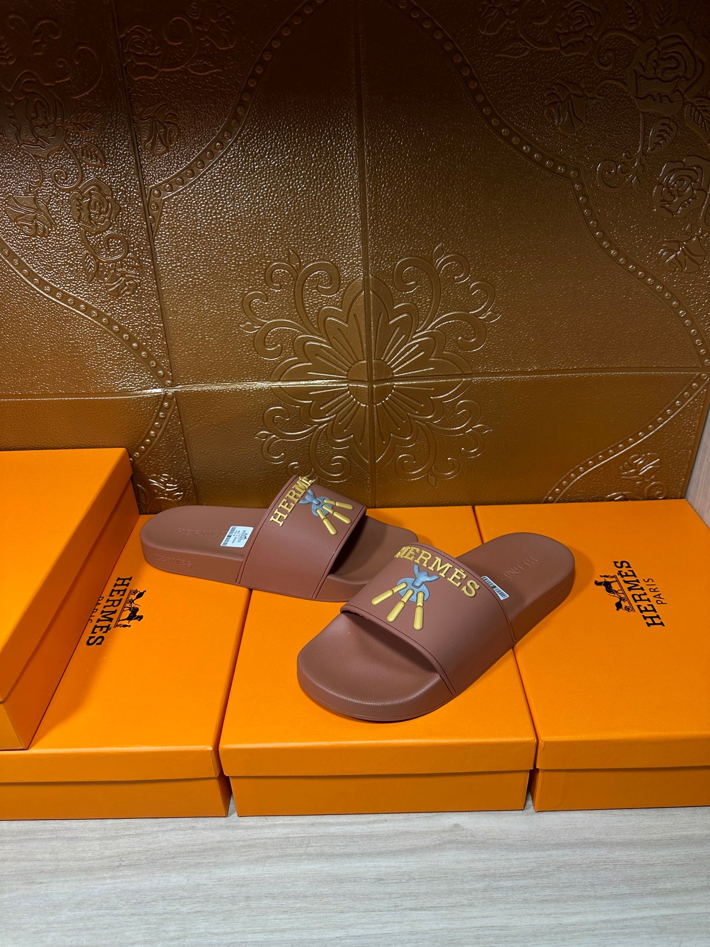 Hermes taupe slide sandals with multicolor logo patch and rectangular size label