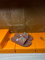 Hermes taupe slide sandals on orange boxes with multicolor logo patch and strap