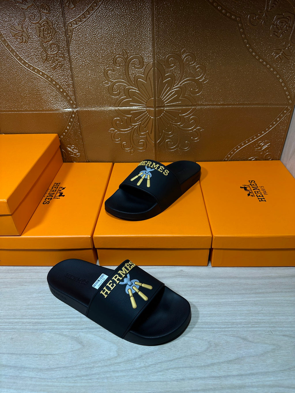Hermes slide sandals, black logo slides resting on a box set.