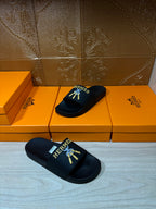 Hermes slide sandals, black logo slides resting on a box set.
