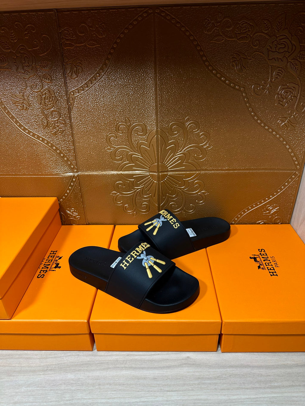 Hermes slide sandals, black slip-on sandals with logo graphic on the footbed strap.