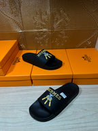 Hermes slide sandals, black slides with logo detail on the front and footbed.