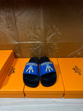 Hermes slide sandals with blue strap, black footbed and gold logo detail