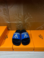 Hermes slide sandals with blue strap, black footbed and gold logo detail