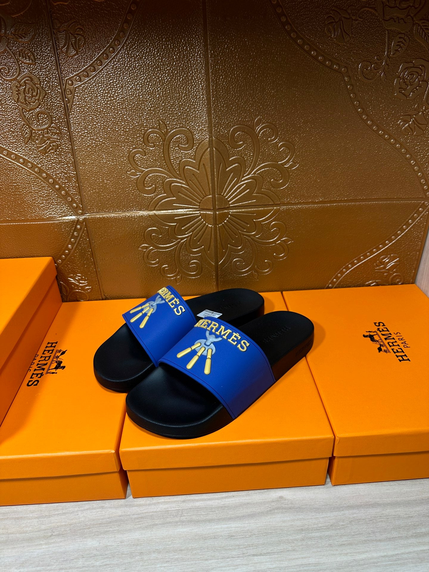 Hermes slide sandals, blue band straps with gold graphic over black soles