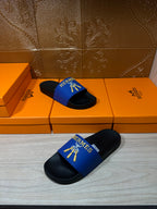 Hermes slide sandals showing blue upper strap with gold emblem and black sole