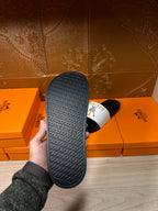 Hermes slide sandal outsole with textured H pattern, held in hand
