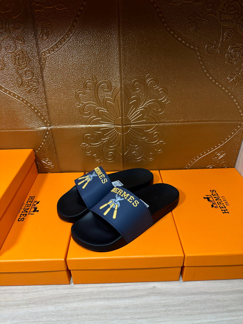 Hermes slide sandals with dark straps and blue logo band, flat black sole