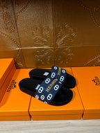 Hermes black slide sandals, top view, navy strap with white H logo