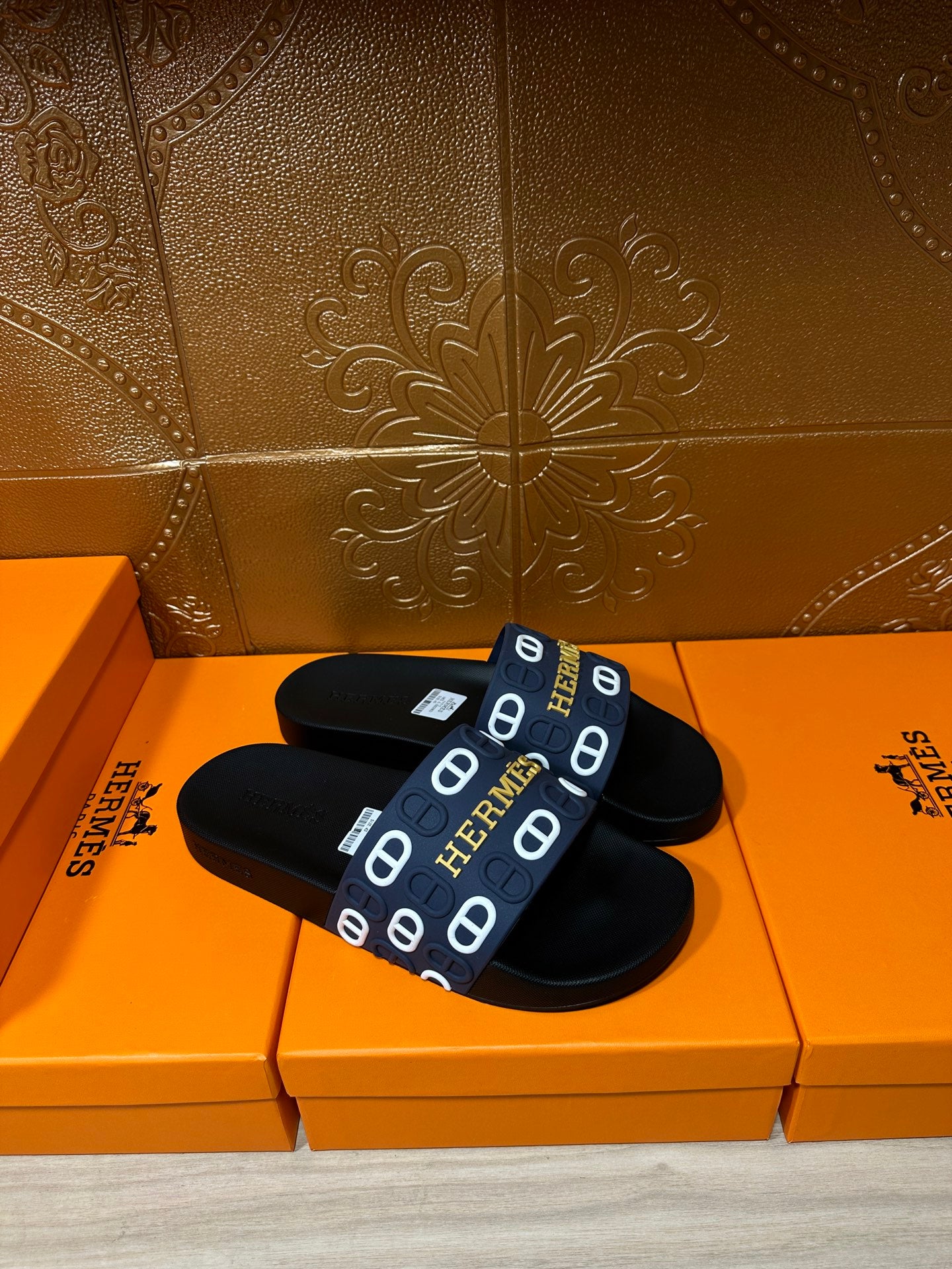 Hermes black slide sandals, top view, navy strap with white H logo