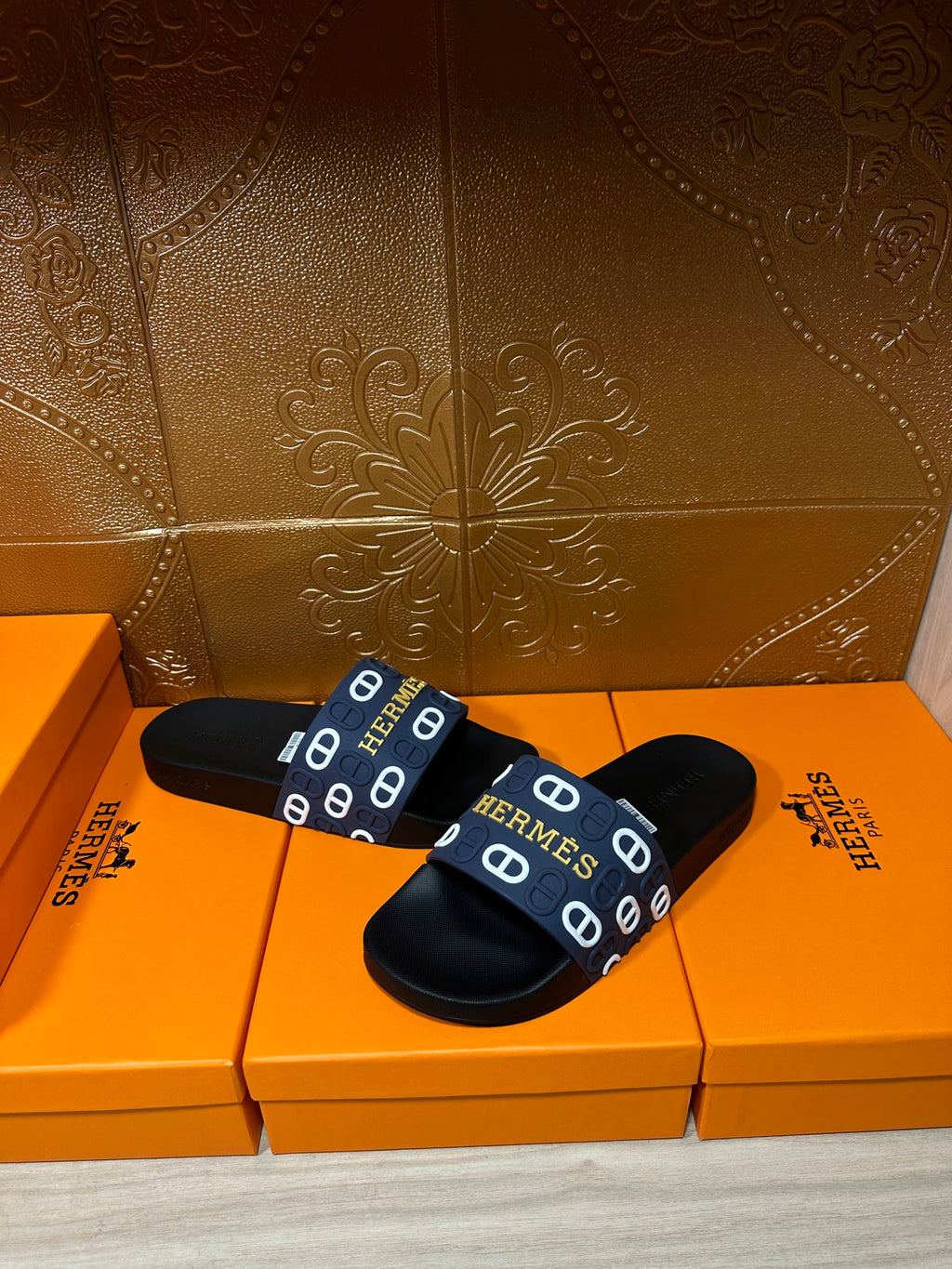 Hermes black slide sandals with navy strap, white H pattern and footbed label