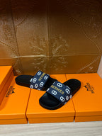 Hermes black slide sandals with navy strap, white H pattern and footbed label