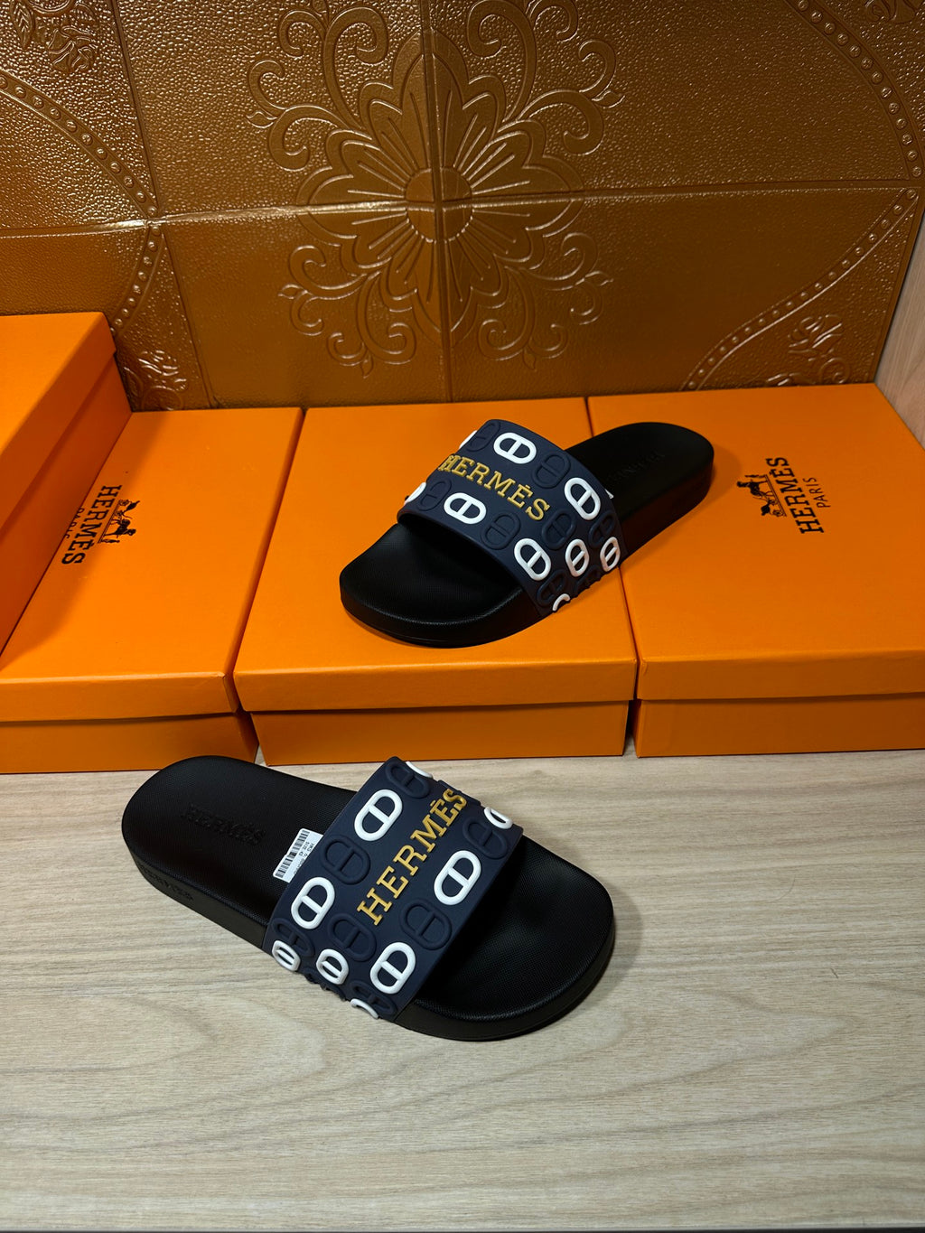 Hermes black slide sandals shown pair on display, navy strap with H print
