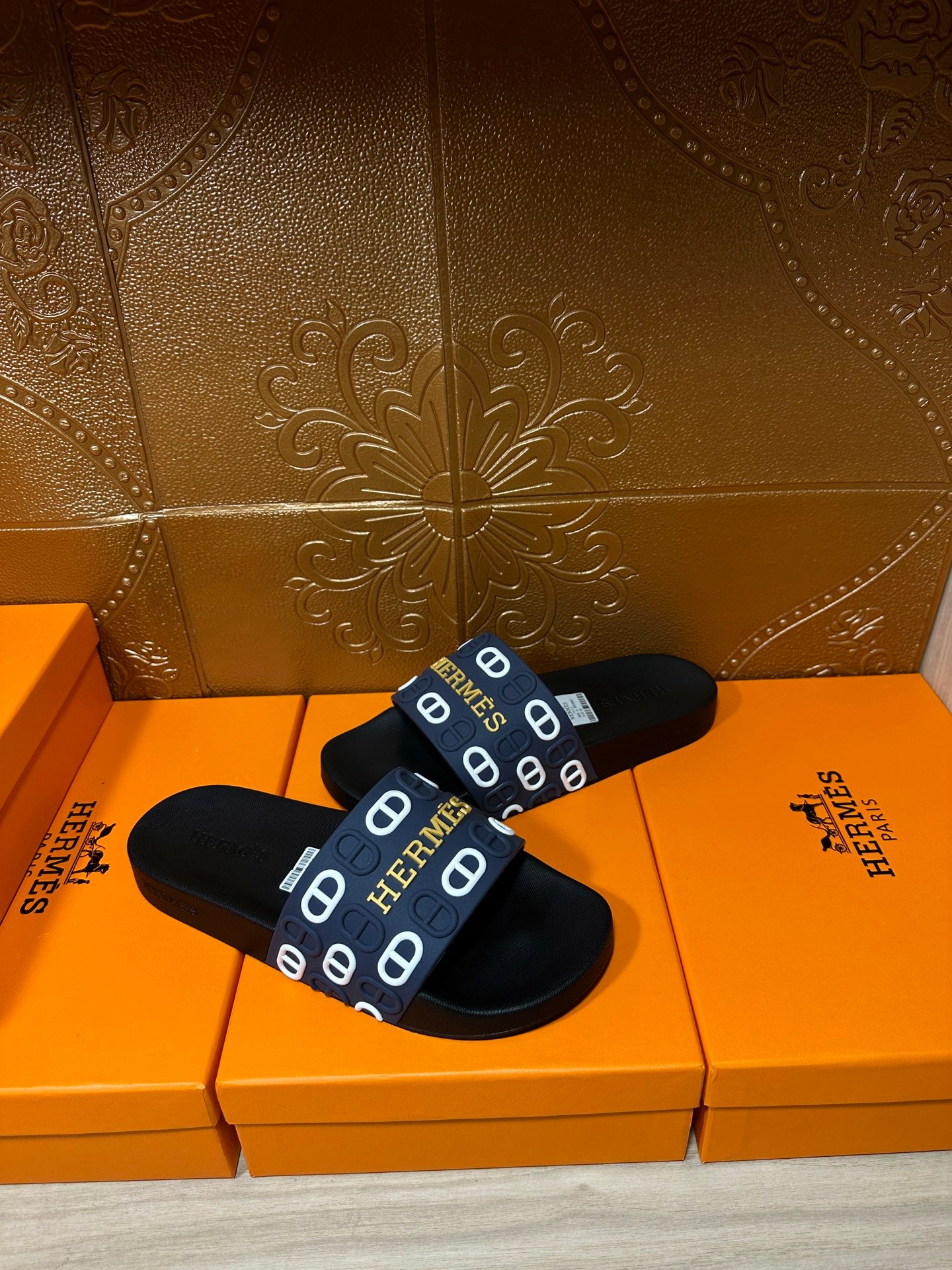 Hermes black slide sandals with navy strap and repeating white H emblems