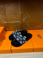 Hermes black slide sandals with navy strap and white H logo pattern