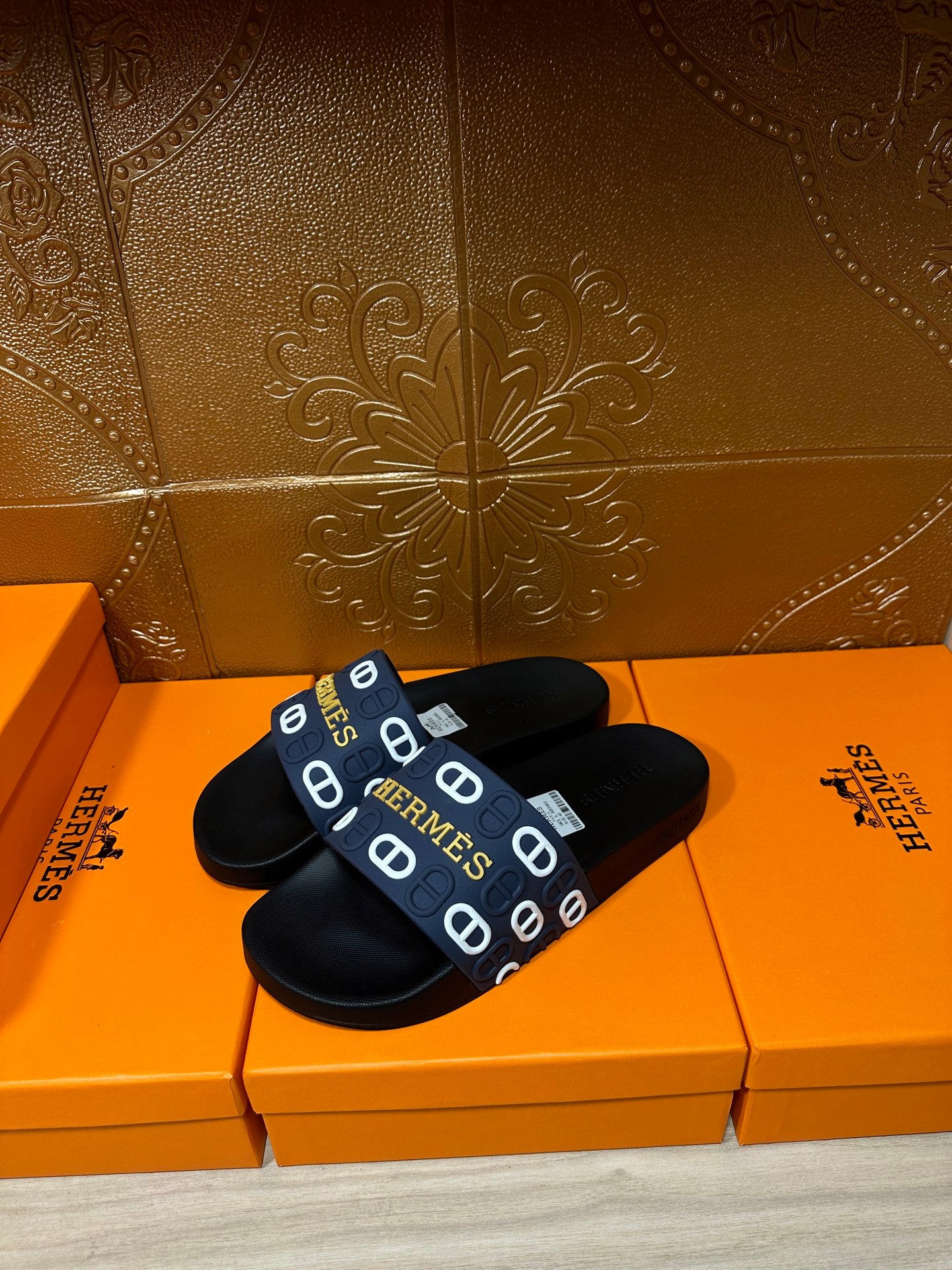 Hermes black slide sandals with navy strap and white H logo pattern