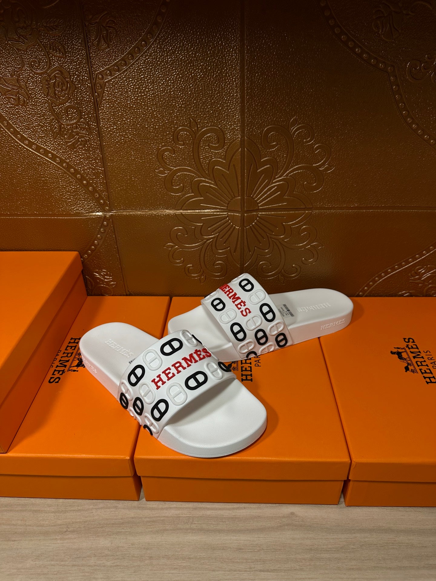 Hermes white slide sandals with black and red logo band on the straps