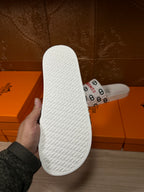 Hermes white slide sandals outsole with textured traction pattern