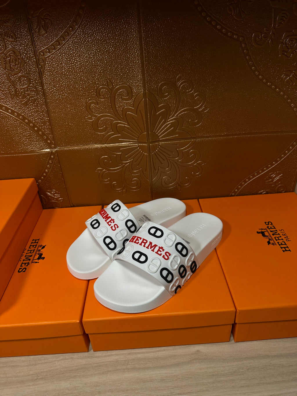 Hermes white slide sandals with logo-printed wide strap across the foot