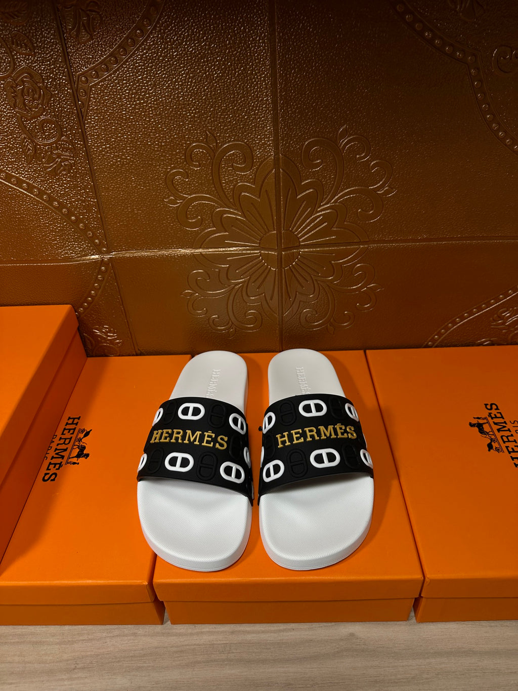 Hermès sandals with black slide strap and white footbed, logo print.