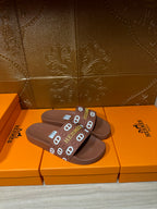 Hermes slide sandals with dark brown footbed and logo-printed strap across top