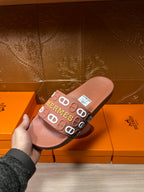 Hermes slide sandal held in hand, light brown footbed with logo-printed strap