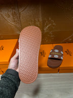 Hermes slide sandal outsole view in pink, textured tread with logo branding
