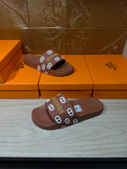 Hermes slide sandals with dark brown slide base and logo-patterned band strap