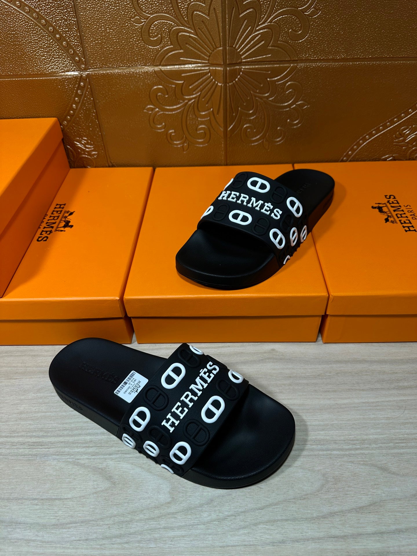 Black slide sandals, pair shown with HERMES logo strap and textured black sole