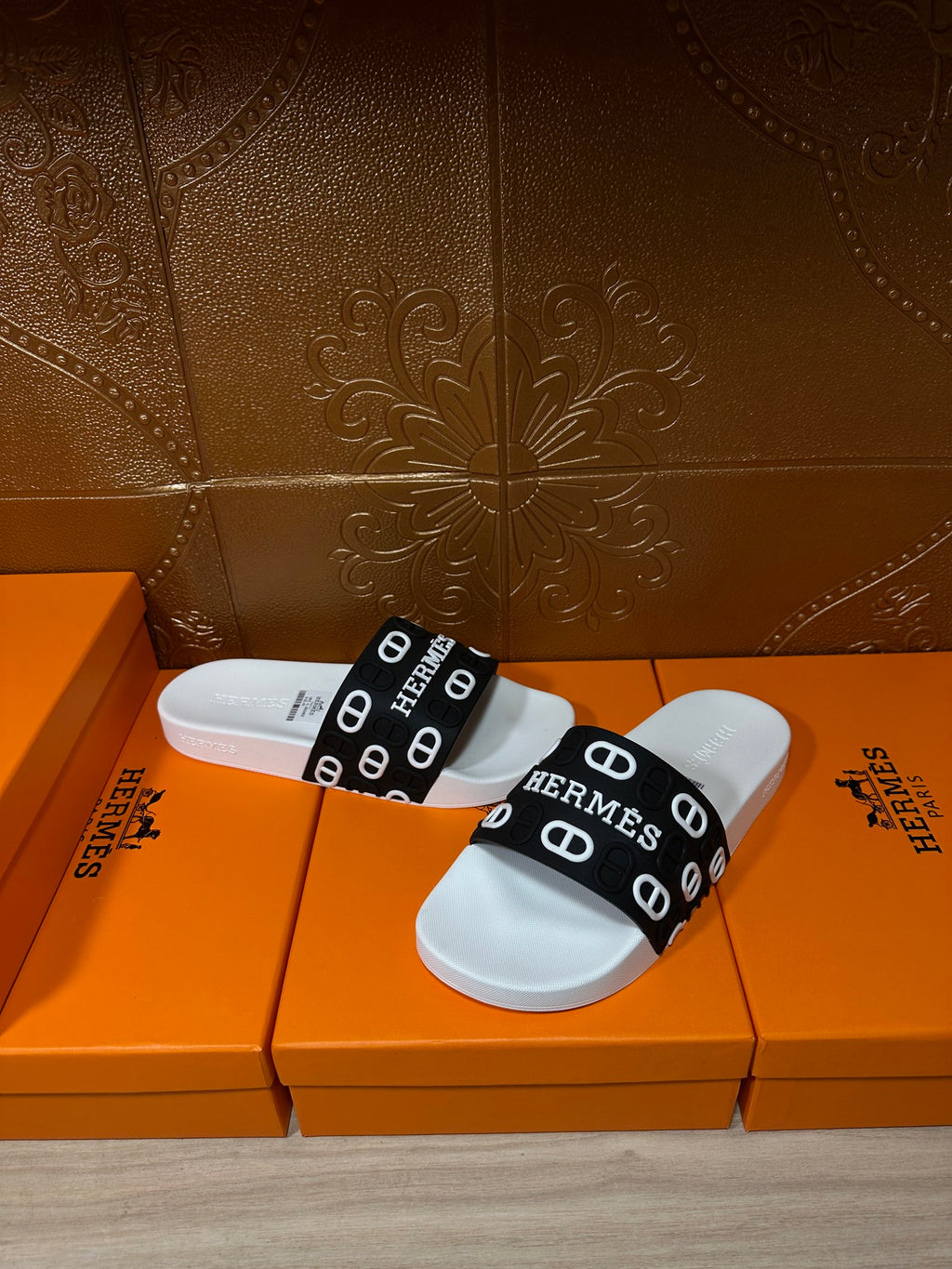 Pair of white slide sandals with black Hermes logo straps and white soles