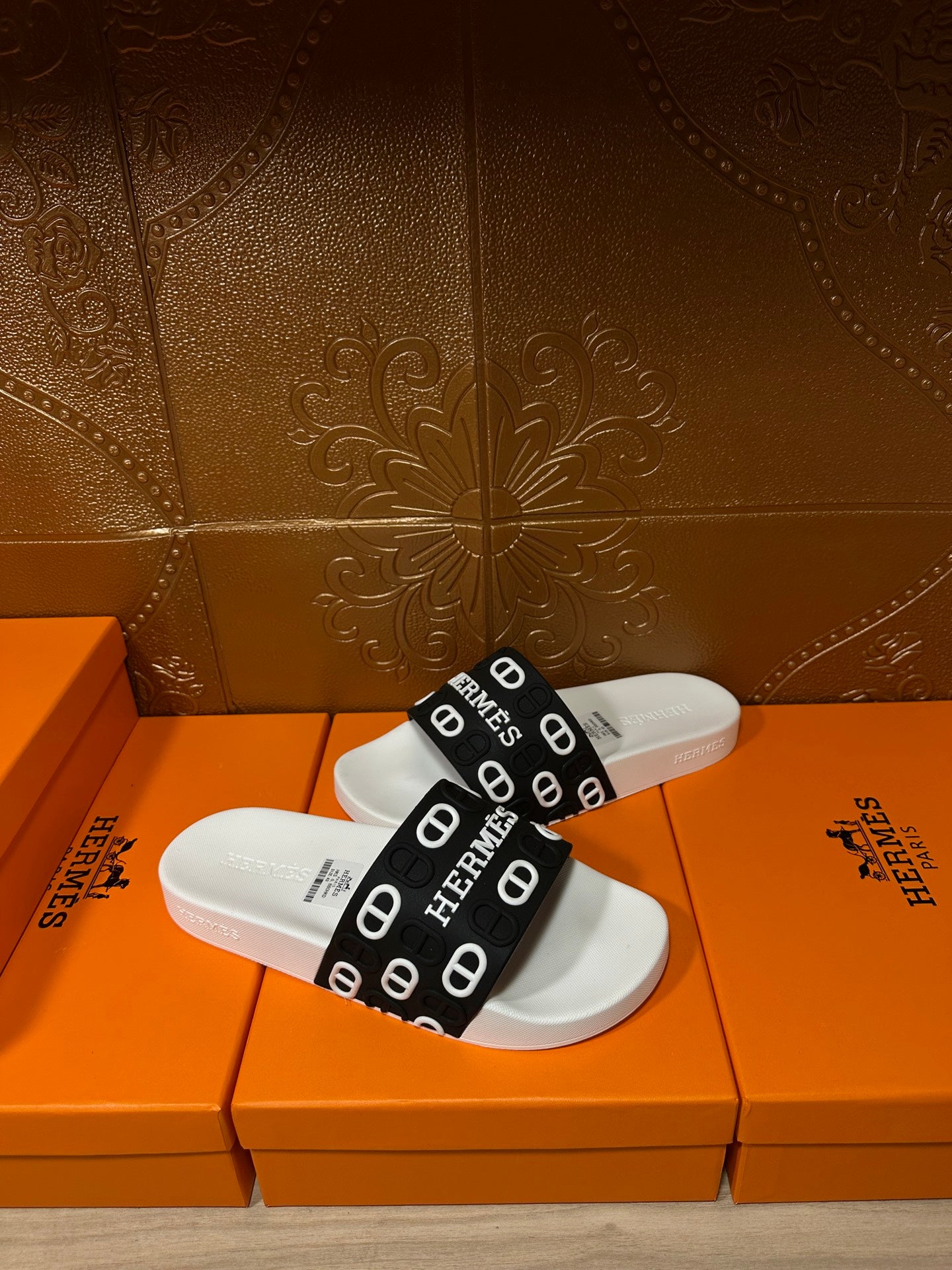 White slide sandal with black Hermes logo strap and cushioned white footbed