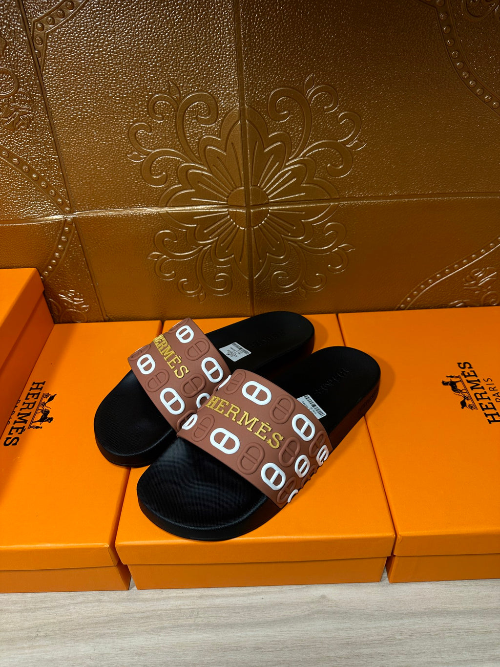 Black slide sandals with brown Hermes logo band strap, open slide