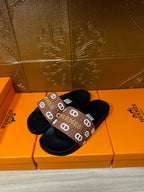 Black slide sandals with brown Hermes logo band strap, open slide