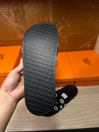 Black slide sandal outsole with raised Hermes logo pattern
