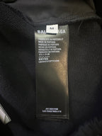 Black pants care label with size M and Portuguese text